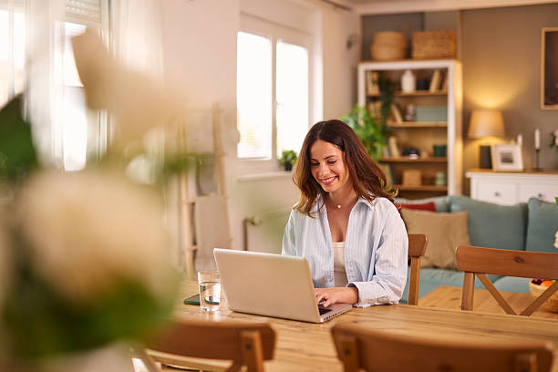 istock Woman working from home smiling and typing on laptop 2224274777