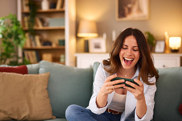 istock Young woman having fun playing mobile games at home 2224274832