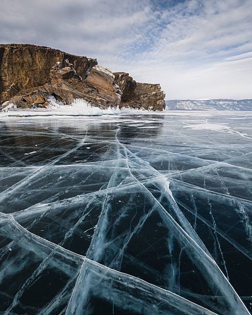 istock Frozen Lake Baikal with cracked ice patterns and rocky cliffs. 2224275969