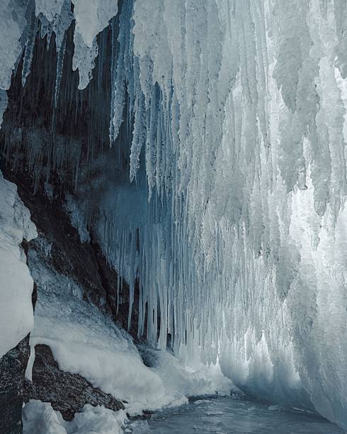 Majestic icicles hang in a frozen cave, showcasing the beauty of winter's natural formations.