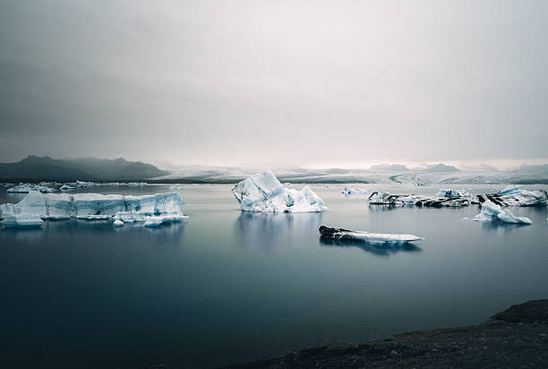 Captivating view of a serene glacial lagoon dotted with icebergs in Iceland, showcasing nature's tranquility.