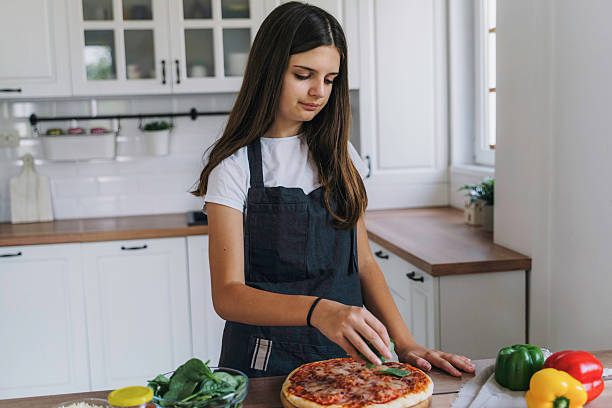 istock Creative girl preparing pizza in a stylish kitchen 2224284136