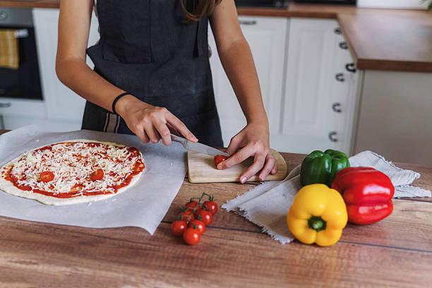 istock Girl Slicing Vegetables for Pizza Preparation 2224284223