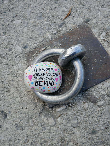 Metal ring for securing boat on dock with be kind kindness rock vertical photo