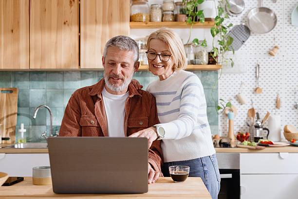 istock Mature Couple Browsing Laptop Together in Kitchen 2224288995