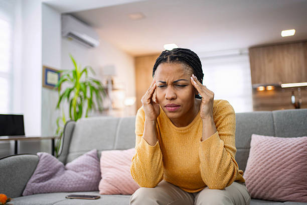 istock Young Woman Suffering From Headache While Sitting On Sofa At Home 2224292383