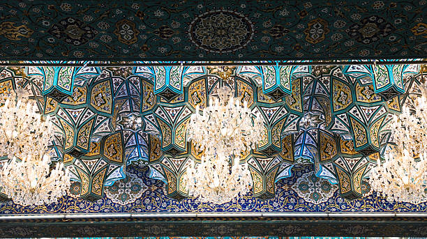 Chandeliers light up intricate tile work at a Karbala shrine in the evening
