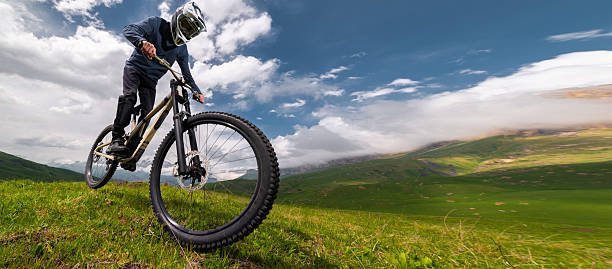 Male mountain biker carves turn on dusty berm in forest, Lillooet, B.C.