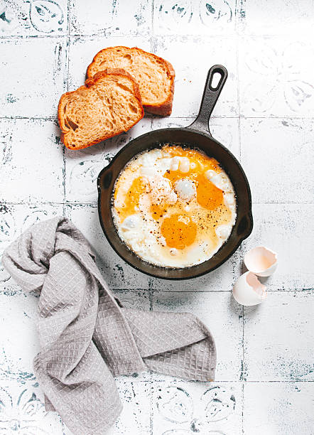 Freshly cooked eggs in a pan, served with bread, on the kitchen counter,breakfast, natural light, no people,