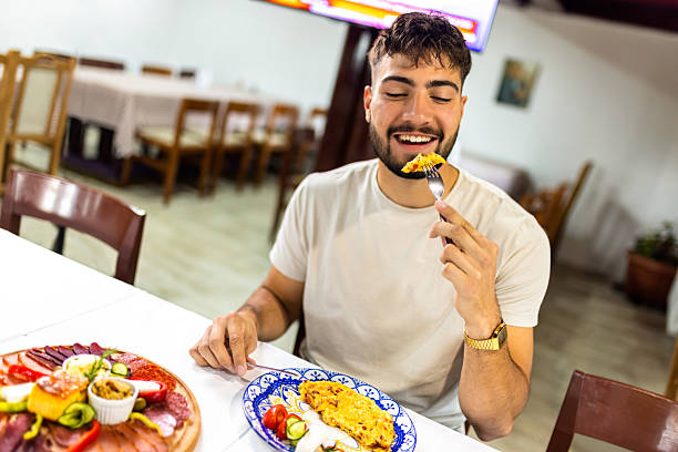 istock Young Man Enjoying Scrambled Eggs and Vegetables for Breakfast 2224301801