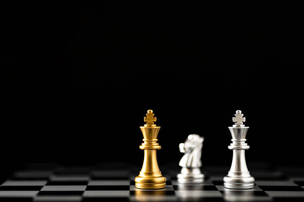istock Gold and silver king chess pieces on a chessboard with a knight. Business strategy, competition, and leadership concept. Planning for negotiation and strategic confrontation. 2224304377