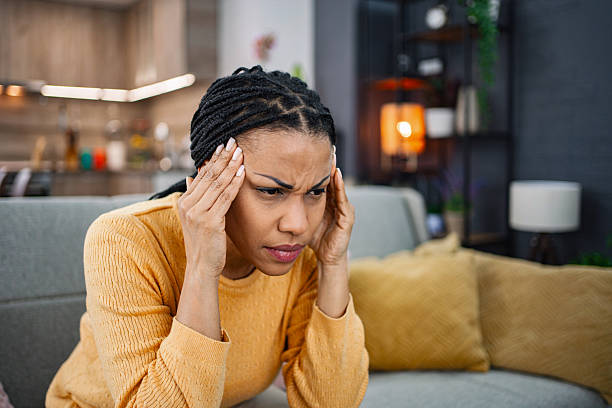 istock Young woman suffering from a headache at home 2224306673