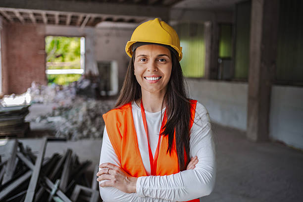 istock Smiling female construction worker posing with crossed arms in a demolition site 2224307814