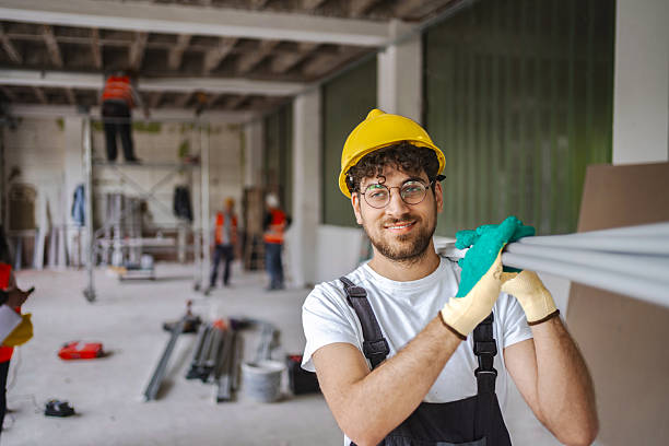 istock Young electrician carrying pipes on his shoulder at construction site 2224307835