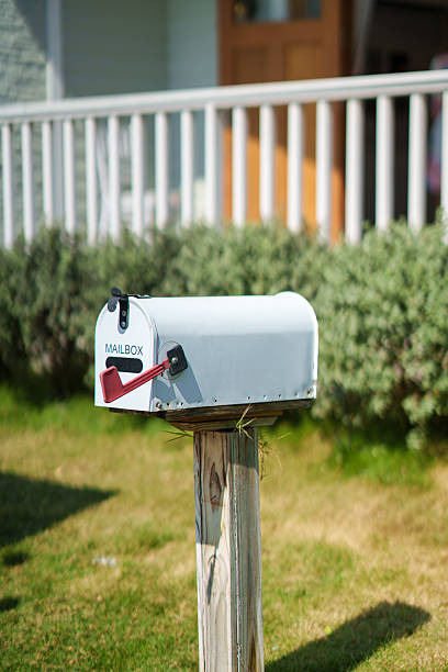 istock White american mailbox set on wooden post at front of house 2224309644
