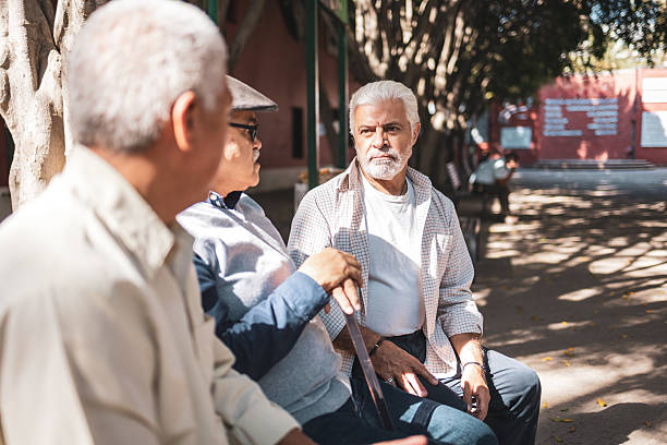istock Elderly friends enjoying conversation in park 2224311356