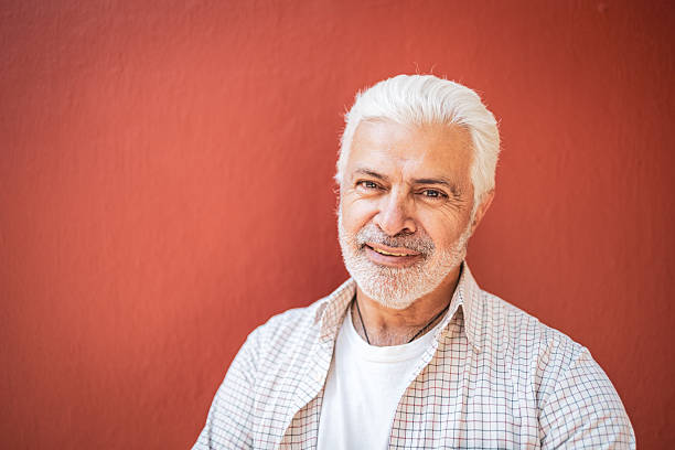 istock Senior man smiling against red background 2224311414