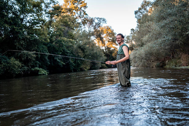 istock Man Enjoying Fly Fishing in a Peaceful River During Sunset 2224311472