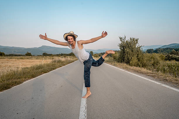 istock Playful Man Joyfully Dancing on Rural Road at Sunset 2224311496