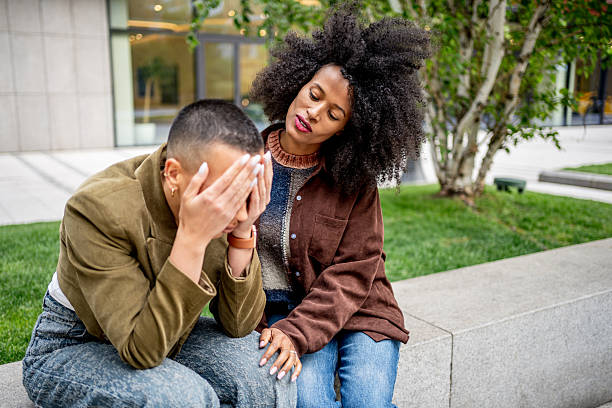 istock Supportive friends comforting each other outdoors 2224311956