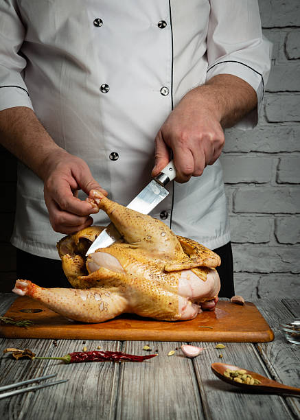 istock A chef skillfully cuts into a perfectly roasted chicken on a wooden cutting board. The rustic kitchen features simple decor, creating a warm and inviting atmosphere 2224313452