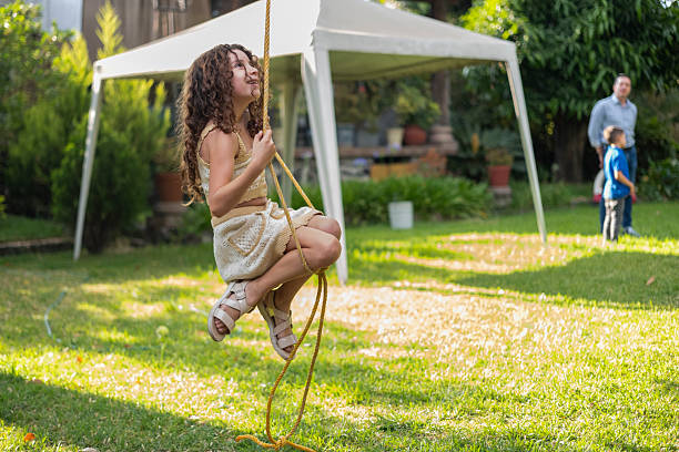 girl playing outdoors with a rope swing