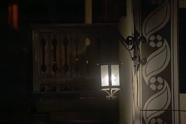 Rustic Wall Lamp Illuminating a Decorative Wooden Structure at Night