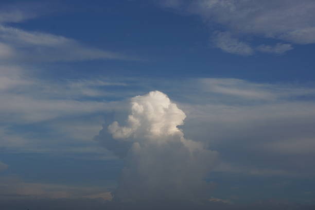 A cumulonimbus cloud is floating in the clear blue sky background