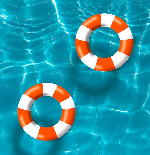 istock Two orange pool float, top view of float in a refreshing blue water. 2224325584