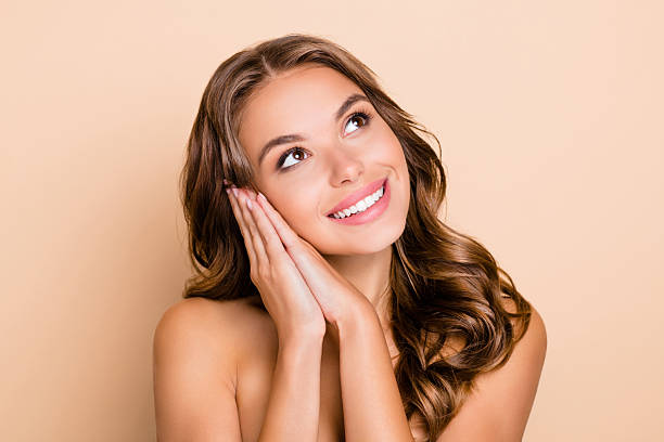istock Photo of nice long hairdo optimistic lady without clothes hands face look empty space isolated on pastel beige color background 2224326069