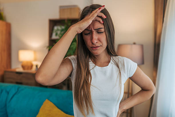 istock Young woman suffering from strong headache at home 2224329712