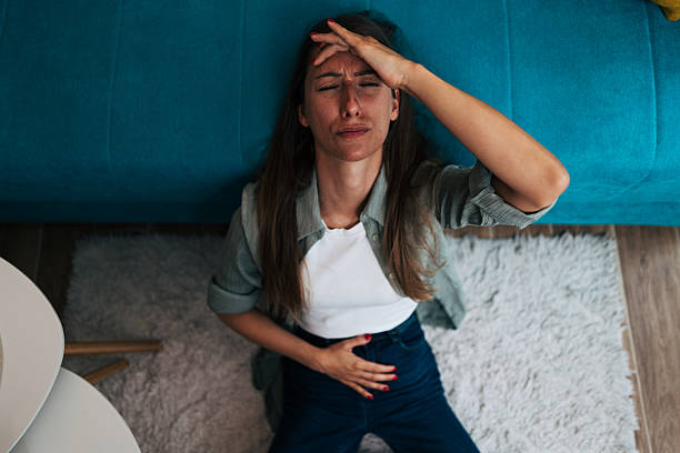 istock Young woman suffering from strong abdominal pains at home 2224331774