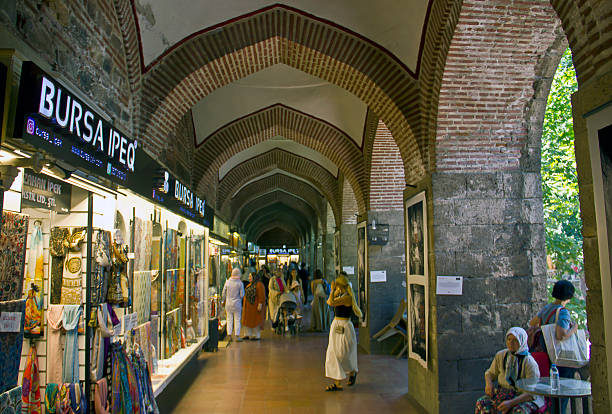Bursa, Turkey - July 5, 2025: Koza Han tea gardens and mosque in Koza Han Silk Bazaar. Koza Han is historical place from Ottoman times in Bursa, Turkey, and a popular tourist attraction.