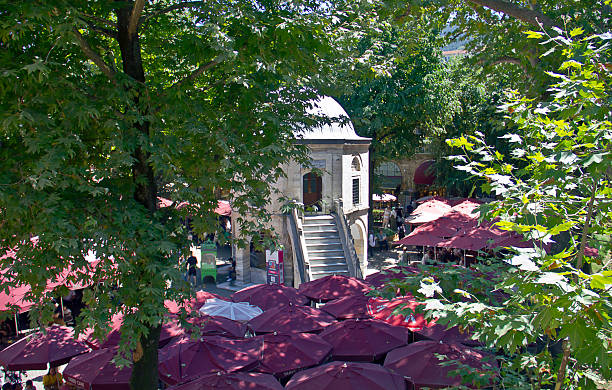 Bursa, Turkey - July 5, 2025: Koza Han tea gardens and mosque in Koza Han Silk Bazaar. Koza Han is historical place from Ottoman times in Bursa, Turkey, and a popular tourist attraction.