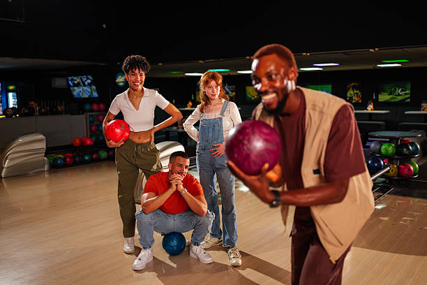 istock Group of young friends enjoying a lively bowling night, laughing and competing while rolling balls down the alley and celebrating strikes 2224335611