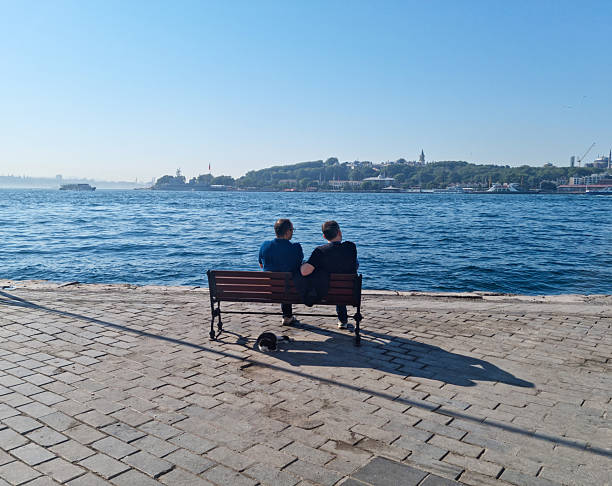 Two friends resting on the bench and relaxing the view