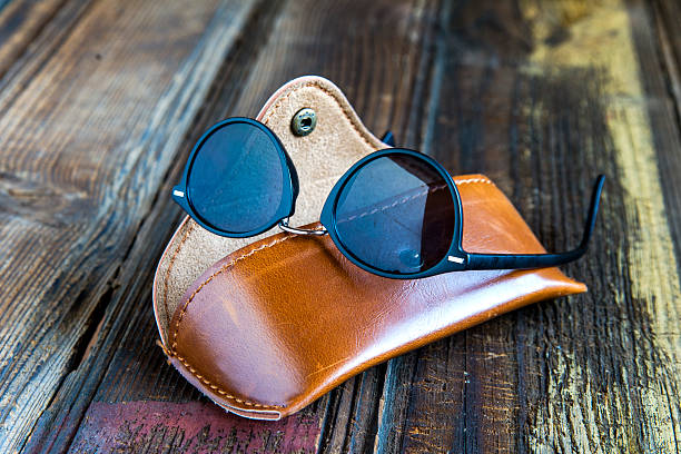 Fashionable sunglasses displayed in an open case, set on a vibrant purple backdrop creating a modern studio look