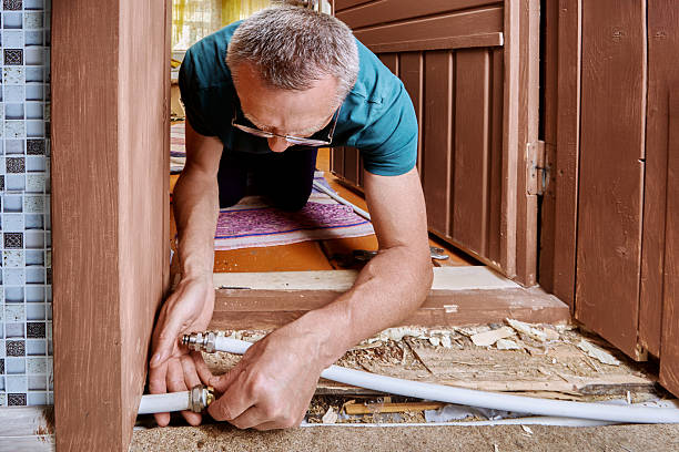 istock Plumber aligns multilayer pipe sections and installs compression coupling to repair water line damaged by freeze-induced crack during winter. 2224346253