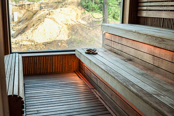 Young woman pouring water on sauna stones