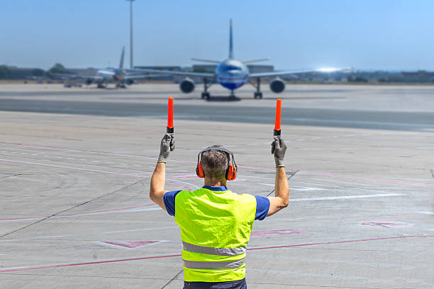 Airport marshaller guiding aircraft on runway