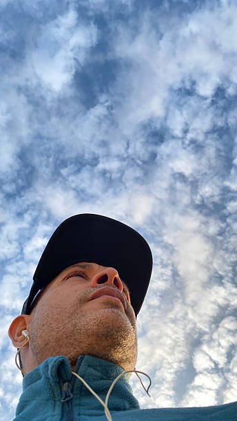 istock Low angle view of man standing against cloudy sky on sunny day 2224384586