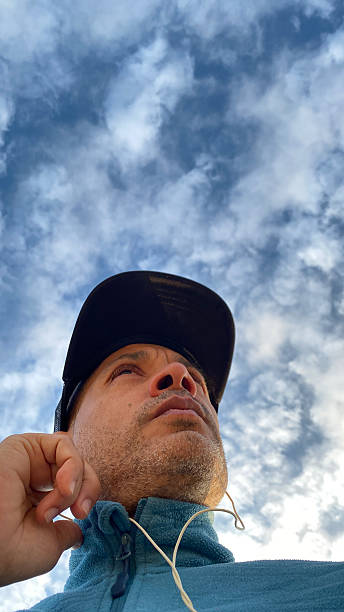 istock Low angle view of men standing against cloudy sky on sunny day 2224384718