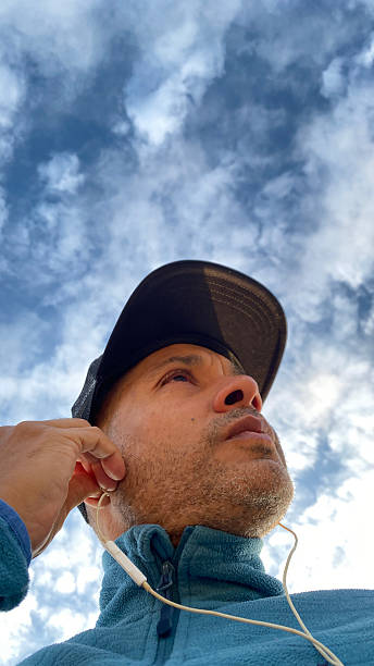 istock Man preparing to run, with headphones, sky on sunny day 2224384807