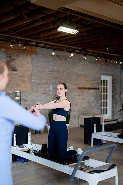 istock Focused Fitness Training Session on Reformer Equipment in Modern Studio Setting 2224400342
