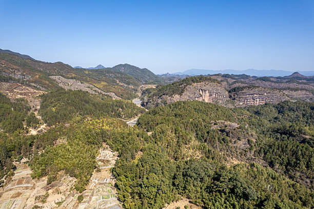 istock An aerial view of rolling mountains and dense forests under clear sunlight, creating a dynamic natural landscape. 2224407276