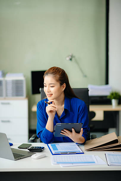istock Woman freelancer is working her job on computer tablet and laptop Doing accounting analysis report real estate investment 2224407962