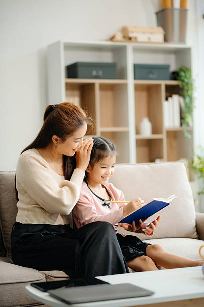 istock A caring mother and young daughter share a bonding moment doing homework at home. 2224407986