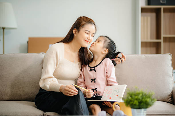 istock A caring mother and young daughter share a bonding moment doing homework at home. 2224407988