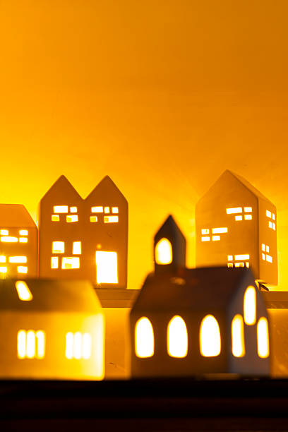 istock Bathed in nostalgic warm candle light, these three ceramic house lamps create a heartfelt Christmas decoration tableau. 2224408208