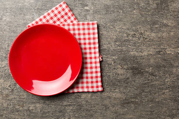 istock Top view on colored background empty round red plate on tablecloth for food. Empty dish on napkin with space for your design 2224422042